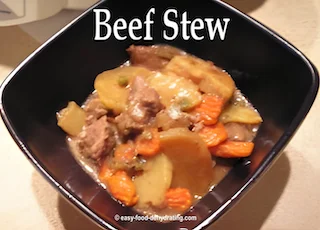 Beef stew in a square bowl with a dark interior