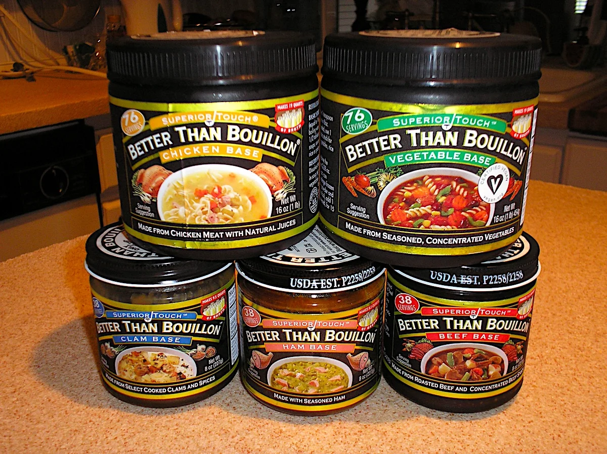 Assortment of Better Than Bouillon jars including chicken, vegetable, beef, clam, and ham bases on a kitchen counter.