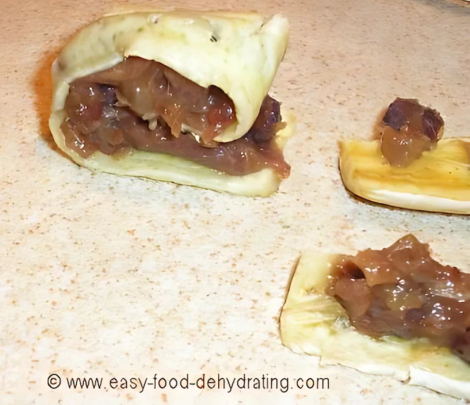 Rolling up the sliced dehydrated bananas and dates with the cinnamon mix