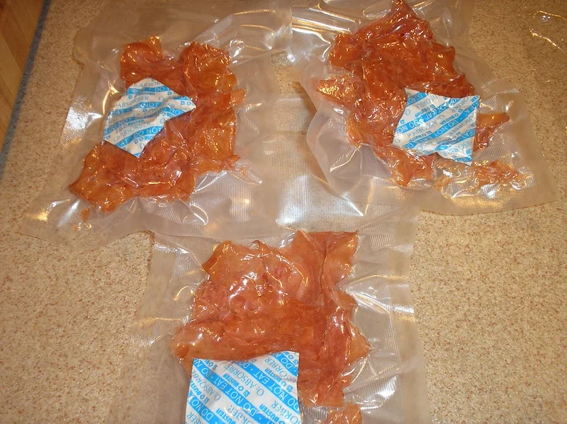 Vacuum-sealed bags of dehydrated sliced turkey with oxygen absorber packets inside for long-term storage.