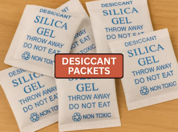 Several silica gel desiccant packets labeled “Do Not Eat” on a wooden surface