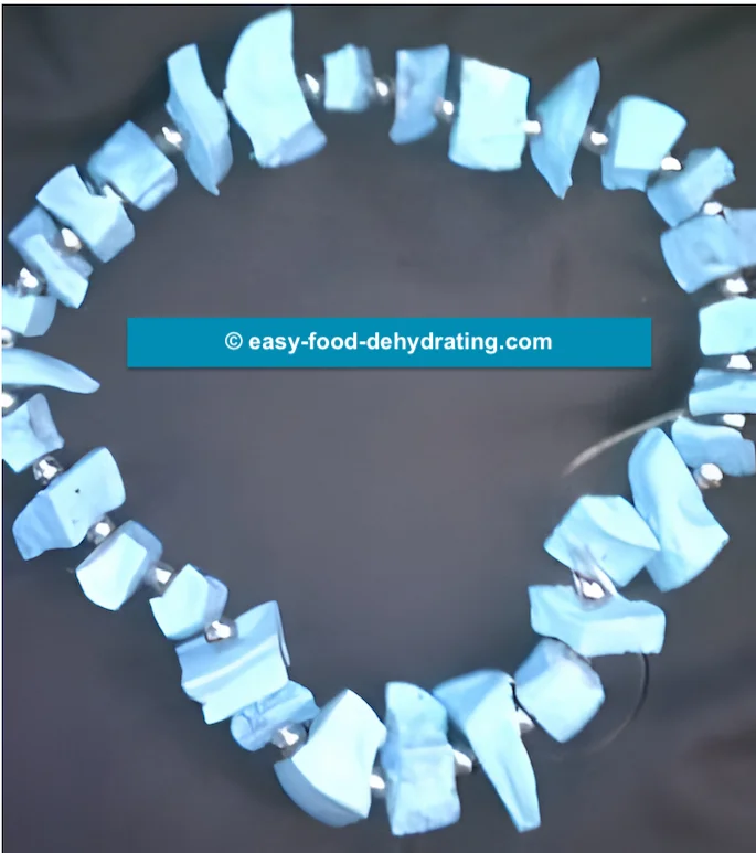 Dehydrated potato-beaded necklace by Janetta! Dehydrated blue painted potato-beaded necklace on a brown background