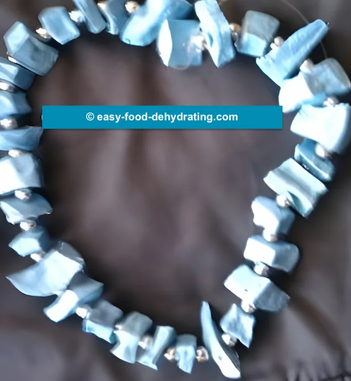 A dehydrated potato beaded necklace, with blue-painted potatoes A dehydrated potato beaded necklace, with blue-painted potatoes