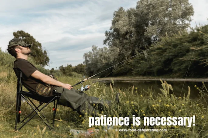 dozing fisherman, rod in hand, waiting patiently for that bite