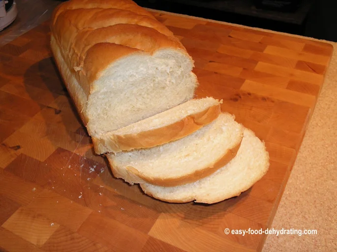 Loaf of bread, sliced, on cutting board Loaf of bread, sliced, on cutting board