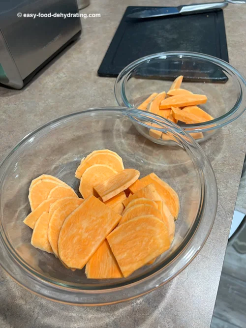 Raw sweet potato evenly sliced and "chips" in two bowls Raw sweet potato evenly sliced and "chips" in two bowls