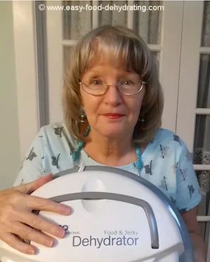 Susan Gast - Owner/Operator of Easy Food Dehydrating - holding a Nesco dehydrator