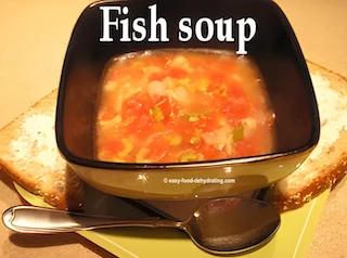 Tuna Fish soup in a square bowl with a spoon, on a plate