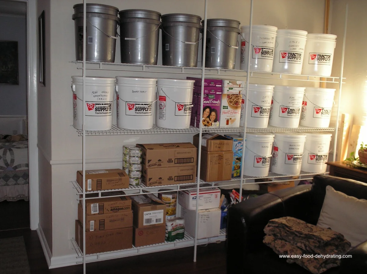 Food Storage Buckets and Wall Shelving Unit for Emergency Prep Wall shelving unit filled with food storage buckets, boxes, and supplies for long-term storage