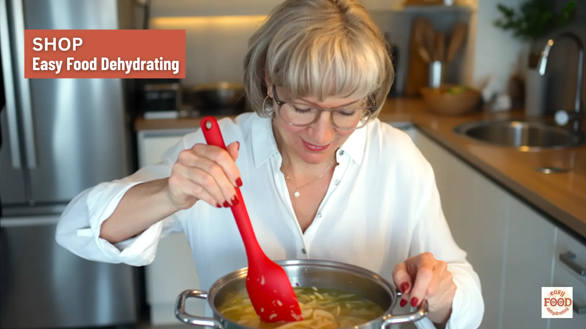 Woman stirring soup with a red silicone spatula, overlaid text reads “Shop Easy Food Dehydrating.”