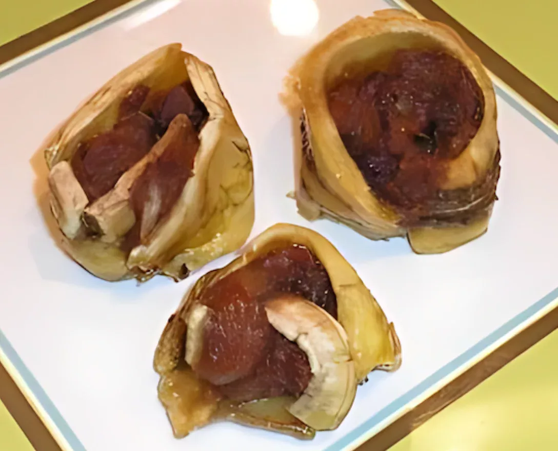 Homemade banana cinnamon rolls on a white plate with caramelized edges.