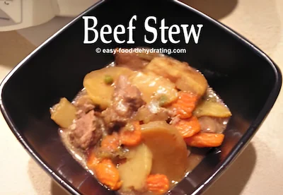 Beef stew in a square bowl with a dark interior
