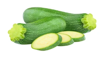 Whole and sliced green zucchinis